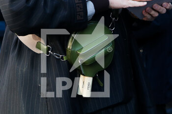 2022-01-15 - A guest wearing bag in the shape of a table tennis paddle arrives at the Fendi red carpet during the MFW 2022 in Milan, Italy, on 15 January 2022 - FENDI - MILAN MEN'S FASHION WEEK - FALL/WINTER 2022 - NEWS - FASHION