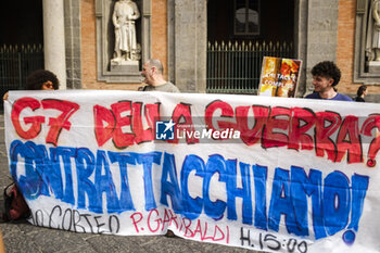 2024-10-16 - All’esterno del palazzo reale di napoli, attivisti La mobilitazione della Rete Napoli contro la Guerra e contro il G7 a napoli 18-19-20 ottobre, espongono uno striscione e cartelli con i volti dei ministri che parteciperanno al summit, e rilanciano la manifestazione del 19 ottobre alla 15 - ITALY: NAPOLI, NO WAR AND NO G7 - NEWS - CHRONICLE