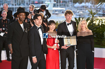 2024-05-25 - Chiang Wei Liang and You Qiao Yin pose with the 'Special Mention Camera d'Or' Award for 'Mongrel', Halfdan Ullmann Tondel poses with the 'Camera d'Or' Award for 'Armand' next to Camera d'Or Jury Co-Presidents Baloji (L) and Emmanuelle Beart (R) during the Palme D'Or Winners Photocall at the 77th annual Cannes Film Festival at Palais des Festivals on May 25, 2024 in Cannes, France. - PALME D'OR WINNERS PHOTOCALL - THE 77TH ANNUAL CANNES FILM FESTIVAL - NEWS - CULTURE
