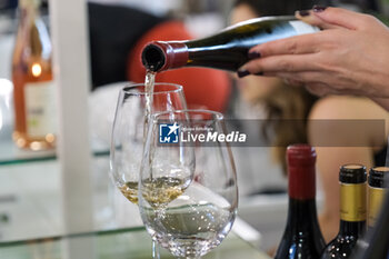 2024-04-14 - Sommeliers serve wine for tasting at the 56th Edition of Vinitaly, Internation exposition of wine and Spirits in Verona fair on April 14, 2024 in Verona. Italy - 56TH EDITION OF VINITALY - INTERNATIONAL EXPO OF WINE AND SPIRITS - NEWS - EVENTS