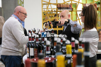 2024-04-14 - Vinitaly visitor tasting a glass of red wine at the 56th Edition of Vinitaly, Internation exposition of wine and Spirits in Verona fair on April 14, 2024 in Verona. Italy - 56TH EDITION OF VINITALY - INTERNATIONAL EXPO OF WINE AND SPIRITS - NEWS - EVENTS