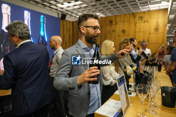 2024-04-14 - Vinitaly exhibitor describer his wines to visitors at the 56th Edition of Vinitaly, Internation exposition of wine and Spirits in Verona fair on April 14, 2024 in Verona. Italy - 56TH EDITION OF VINITALY - INTERNATIONAL EXPO OF WINE AND SPIRITS - NEWS - EVENTS