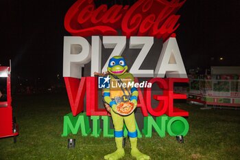 2024-09-06 - Logo of the event with Leonardo delle Tartarughe nija with pizza - COCA-COLA PIZZA VILLAGE MILAN - NEWS - EVENTS