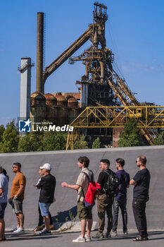 2024-06-24 - At the Park Gate of the former Italsider industrial area two profiling days open, where it will be possible to apply for the job profiles required in the calls for applications, a queue of people are about to apply for jobs to start the reclamation of the area - FIRST PROFILING DAY FOR FORMER ITALSIDER AREA RECLAMATION WORKERS  - NEWS - WORK