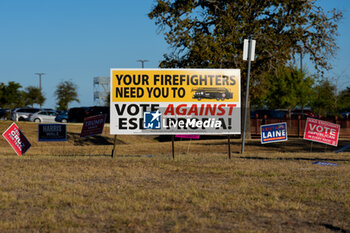 2024-11-05 - Campaign signs are seen in the foreground as cars line up to enter a parking lot outside a polling place in the final hours of voting on Election Day. Voters across the state capital area were met with short lines at most polling places throughout the day, as more than 9 million Texans took advantage of the state’s early voting period. - VOTING DAY - UNITED STATES PRESIDENTIAL ELECTION IN TEXAS - NEWS - POLITICS