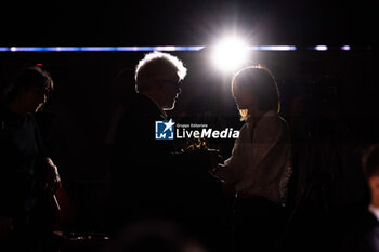 2024-09-07 - Pedro Almodovar (silhouette) taking an interview holding the golden Lion Award for The room next door