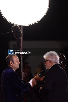 2024-09-07 - Pedro Almodovar taking an interview holding the golden Lion Award for The room next door