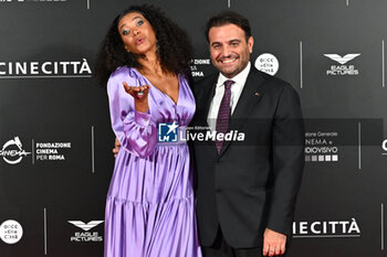 2024-10-14 - Denny Mendez and Gimmi Cangiano attend the red carpet for the film Megalopolis at Cinecitta Studios on October 14, 2024 in Rome, Italy.

 - RED CARPET MEGALOPOLIS - NEWS - VIP