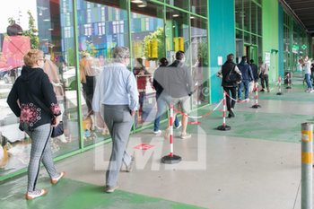 2020-05-18 - Apertura di negozio di calzature, all'interno di un centro commerciale, le persone in coda all'ingresso, sul pavimento gli adesivi distanziatori - RIAPERTURA ATTIVITà COMMERCIALI DELLA FASE 2 DELLA RIPRESA DALL'EMERGENZA CORONAVIRUS - NEWS - WORK