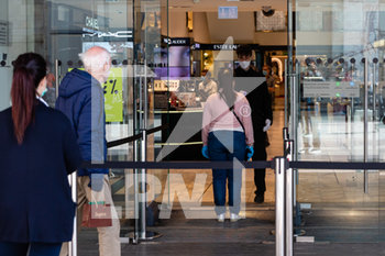 2020-05-18 - Clienti in coda in attesa di entrare nei negozi a Milano  - RIAPERTURA NEGOZI E RISTORANTI E LAVORI DI SANIFICAZIONE NELLA FASE 2 COVID-19 - NEWS - WORK