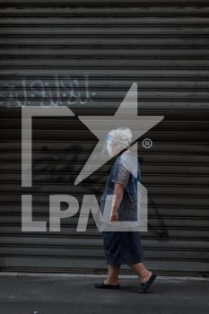 2020-05-23 - Una donna passeggia davanti ad un locale chiuso con mascherina e visiera anti covi19. - RIAPERTURA DELLE ATTIVITà DI RISTORAZIONE A ROMA NELLA FASE 2 DELL'EMERGENZA COVID-19 - NEWS - WORK