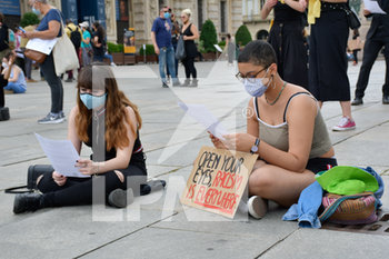 2020-06-06 - Manifestanti sedute leggono il volantino della protesta - "I CAN'T BREATHE" - FLASH MOB PER LA MORTE DI GEORGE FLOYD - NEWS - SOCIETY