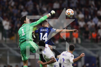 2021-09-15 - Thibaut Courtois of Real Madrid CF fights for the ball against Ivan Perisic of FC Internazionale during the UEFA Champions League 2021/22 Group Stage - Group D football match between FC Internazionale and Real Madrid CF at Giuseppe Meazza Stadium, Milan, Italy on September 15, 2021 - GROUP D - INTER - FC INTERNAZIONALE VS REAL MADRID - UEFA CHAMPIONS LEAGUE - SOCCER