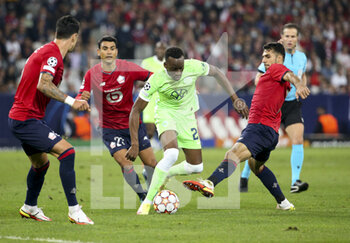 2021-09-14 - Dodi Lukebakio of Wolfsburg between Benjamin Andre and Mehmet Zeki Celik of Lille during the UEFA Champions League, Group Stage, Group G football match between Lille OSC (LOSC) and VfL Wolfsburg on September 14, 2021 at Stade Pierre Mauroy in Villeneuve-d?Ascq near Lille, France - LILLE OSC (LOSC) AND VEREIN FUR LEIBESUBUNGEN WOLFSBURG - UEFA CHAMPIONS LEAGUE - SOCCER