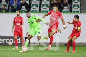 2021-09-29 - Dodi Lukebakio of Wolfsburg and Diego Carlos of Sevilla during the UEFA Champions League, Group G football match between VfL Wolfsburg and FC Sevilla on September 29, 2021 at Volkswagen Arena in Wolfsburg, Germany - VFL WOLFSBURG VS FC SEVILLA - UEFA CHAMPIONS LEAGUE - SOCCER