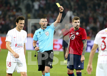 2021-10-20 - Referee Michael Oliver of England gives a yellow card during the UEFA Champions League, Group G football match between Lille OSC (LOSC) and Sevilla FC on October 20, 2021 at Stade Pierre Mauroy in Villeneuve-d'Ascq near Lille, France - LILLE OSC (LOSC) VS SEVILLA FC - UEFA CHAMPIONS LEAGUE - SOCCER