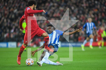 2021-11-24 - FC Porto's defender Zaidu Sanusi (12) challenges Liverpool's forward Mohamed Salah (11) during the UEFA Champions League, Group B football match between Liverpool FC and FC Porto on November 24, 2021 at Anfield stadium in Liverpool, England - LIVERPOOL FC VS FC PORTO - UEFA CHAMPIONS LEAGUE - SOCCER