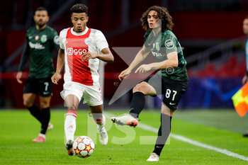 2021-12-07 - David Neres of Ajax battles for the ball with Goncalo Esteves of Sporting CP during the UEFA Champions League, Group C football match between Ajax and Sporting Clube de Portugal on December 7, 2021 at Johan Cruijff ArenA in Amsterdam, Netherlands - AJAX VS SPORTING CLUBE DE PORTUGAL - UEFA CHAMPIONS LEAGUE - SOCCER