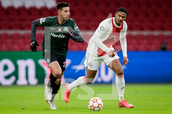 2021-12-07 - Matheus Reis of Sporting CP battles for the ball with Sebastien Haller of Ajax during the UEFA Champions League, Group C football match between Ajax and Sporting Clube de Portugal on December 7, 2021 at Johan Cruijff ArenA in Amsterdam, Netherlands - AJAX VS SPORTING CLUBE DE PORTUGAL - UEFA CHAMPIONS LEAGUE - SOCCER