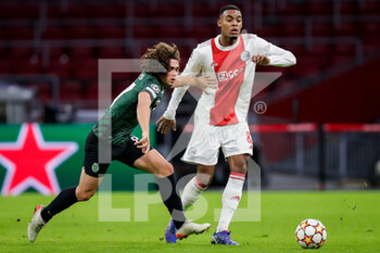 2021-12-07 - Goncalo Esteves of Sporting CP battles for the ball with Ryan Gravenberch of Ajax during the UEFA Champions League, Group C football match between Ajax and Sporting Clube de Portugal on December 7, 2021 at Johan Cruijff ArenA in Amsterdam, Netherlands - AJAX VS SPORTING CLUBE DE PORTUGAL - UEFA CHAMPIONS LEAGUE - SOCCER