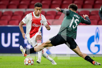 2021-12-07 - David Neres of Ajax battles for the ball with Manuel Ugarte of Sporting CP during the UEFA Champions League, Group C football match between Ajax and Sporting Clube de Portugal on December 7, 2021 at Johan Cruijff ArenA in Amsterdam, Netherlands - AJAX VS SPORTING CLUBE DE PORTUGAL - UEFA CHAMPIONS LEAGUE - SOCCER