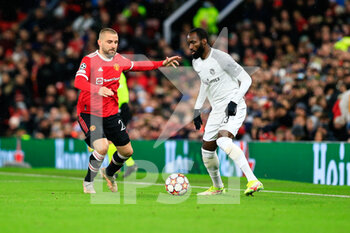 2021-12-08 - MANCHESTER, ENGLAND - DECEMBER 08: Nicolas Moumi Ngamaleu of Young Boys (R) against Luke Shaw of Manchester United (L) during the UEFA Champions League group F match between Manchester United and BSC Young Boys at Old Trafford on December 8, 2021 in Manchester, United Kingdom. - MANCHESTER UNITED VS BSC YOUNG BOYS - UEFA CHAMPIONS LEAGUE - SOCCER