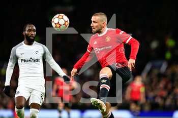 2021-12-08 - MANCHESTER, ENGLAND - DECEMBER 08: Luke Shaw of Manchester United (R) controls the ball during the UEFA Champions League group F match between Manchester United and BSC Young Boys at Old Trafford on December 8, 2021 in Manchester, United Kingdom. - MANCHESTER UNITED VS BSC YOUNG BOYS - UEFA CHAMPIONS LEAGUE - SOCCER