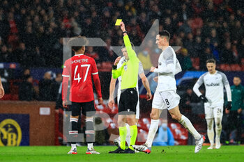 2021-12-08 - MANCHESTER, ENGLAND - DECEMBER 08: referee Benoit Bastien shows a yellow card to Shola Shoretire of Manchester United (L) during the UEFA Champions League group F match between Manchester United and BSC Young Boys at Old Trafford on December 8, 2021 in Manchester, United Kingdom. - MANCHESTER UNITED VS BSC YOUNG BOYS - UEFA CHAMPIONS LEAGUE - SOCCER