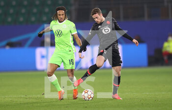 2021-12-08 - Gabriel Gudmundsson of Lille and Kevin Mbabu of Wolfsburg during the UEFA Champions League, Group G football match between VfL Wolfsburg and LOSC Lille on December 8, 2021 at Volkswagen Arena in Wolfsburg, Germany - VFL WOLFSBURG VS LOSC LILLE - UEFA CHAMPIONS LEAGUE - SOCCER