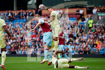 2021-09-18 - Burnley forward Chris Wood (9) challenges with Arsenal defender Ben White (4) in the air during the Premier League match between Burnley and Arsenal at Turf Moor, Burnley, England on 18 September 2021. Photo Simon Davies /ProSportsImages / DPPI - BURNLEY VS ARSENAL - ENGLISH PREMIER LEAGUE - SOCCER