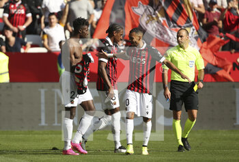 2021-10-24 - Evann Guessand of Nice celebrates his winning goal with Pablo Rosario, Alexis Claude-Maurice of Nice while referee Jerome Brisard will give a yellow card for taking off his shirt during the French championship Ligue 1 football match between OGC Nice (OGCN) and Olympique Lyonnais (OL) on October 24, 2021 at Allianz Riviera stadium in Nice, France - OGC NICE (OGCN) VS OLYMPIQUE LYONNAIS (OL) - FRENCH LIGUE 1 - SOCCER