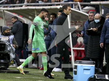 2021-12-11 - Denis Bouanga of Saint-Etienne leaves the pitch after receiving a red card while coach of AS Saint-Etienne Julien Sable (right) looks on during the French championship Ligue 1 football match between Stade de Reims and AS Saint-Etienne (ASSE) on December 11, 2021 at Stade Auguste Delaune in Reims, France - STADE DE REIMS VS AS SAINT-ETIENNE (ASSE) - FRENCH LIGUE 1 - SOCCER