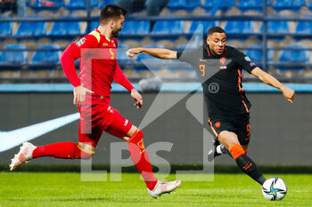 2021-11-13 - Igor Vujacic of Montenegro battles for the ball with Arnaut Danjuma of the Netherlands during the FIFA World Cup 2022, Qualifiers Group G football match between Montenegro and Netherlands on November 13, 2021 at Gradski Stadion Podgorica in Podgorica, Montenegro - FIFA WORLD CUP 2022, QUALIFIERS GROUP G - MONTENEGRO VS NETHERLANDS - FIFA WORLD CUP - SOCCER