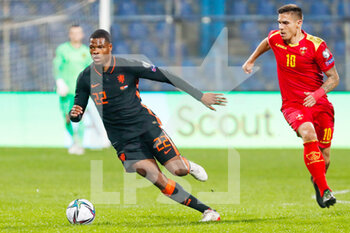 2021-11-13 - Denzel Dumfries of the Netherlands battles for the ball with Uros Djurdjevic of Montenegro during the FIFA World Cup 2022, Qualifiers Group G football match between Montenegro and Netherlands on November 13, 2021 at Gradski Stadion Podgorica in Podgorica, Montenegro - FIFA WORLD CUP 2022, QUALIFIERS GROUP G - MONTENEGRO VS NETHERLANDS - FIFA WORLD CUP - SOCCER