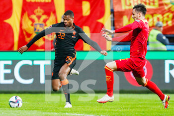2021-11-13 - Denzel Dumfries of the Netherlands battles for the ball with Zarko Tomasevic of Montenegro during the FIFA World Cup 2022, Qualifiers Group G football match between Montenegro and Netherlands on November 13, 2021 at Gradski Stadion Podgorica in Podgorica, Montenegro - FIFA WORLD CUP 2022, QUALIFIERS GROUP G - MONTENEGRO VS NETHERLANDS - FIFA WORLD CUP - SOCCER