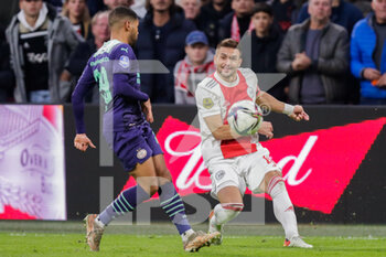 2021-10-24 - Phillipp Mwene of PSV battles for the ball with Dusan Tadic of Ajax during the Netherlands championship Eredivisie football match between Ajax and PSV on October 24, 2021 at Johan Cruijff Arena in Amsterdam, Netherlands - AJAX VS PSV - NETHERLANDS EREDIVISIE - SOCCER