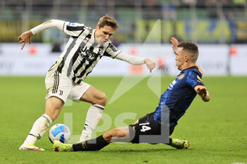 2021-10-24 - Federico Chiesa of Juventus FC fights for the ball against Ivan Perisic of FC Internazionale during the Serie A 2021/22 football match between FC Internazionale and Juventus FC at Giuseppe Meazza Stadium, Milan, Italy on October 24, 2021 - INTER - FC INTERNAZIONALE VS JUVENTUS FC - ITALIAN SERIE A - SOCCER