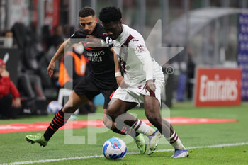 2021-10-26 - Ola Aina of Torino FC fights for the ball against Ismael Bennacer of AC Milan during the Serie A 2021/22 football match between AC Milan and Torino FC at Giuseppe Meazza Stadium, Milan, Italy on October 26, 2021 - AC MILAN VS TORINO FC - ITALIAN SERIE A - SOCCER