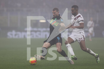 2021-12-22 - Edin Dzeko of FC Internazionale fights for the ball against Koffi Djidji of Torino FC during the Serie A 2021/22 football match between FC Internazionale and Torino FC at Giuseppe Meazza Stadium, Milan, Italy on December 22, 2021 - INTER - FC INTERNAZIONALE VS TORINO FC - ITALIAN SERIE A - SOCCER