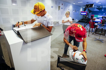 2021-12-09 - NORRIS Lando (gbr), McLaren MCL35M, LECLERC Charles (mco), Scuderia Ferrari SF21, portrait signing helmet and book for TODT Jean (fra), FIA President during the Formula 1 Etihad Airways Abu Dhabi Grand Prix 2021, 22th round of the 2021 FIA Formula One World Championship from December 10 to 12, 2021 on the Yas Marina Circuit, in Yas Island, Abu Dhabi - FORMULA 1 ETIHAD AIRWAYS ABU DHABI GRAND PRIX 2021, 22TH ROUND OF THE 2021 FIA FORMULA ONE WORLD CHAMPIONSHIP - FORMULA 1 - MOTORS