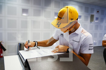 2021-12-09 - NORRIS Lando (gbr), McLaren MCL35M, portrait signing helmet and book for TODT Jean (fra), FIA President during the Formula 1 Etihad Airways Abu Dhabi Grand Prix 2021, 22th round of the 2021 FIA Formula One World Championship from December 10 to 12, 2021 on the Yas Marina Circuit, in Yas Island, Abu Dhabi - FORMULA 1 ETIHAD AIRWAYS ABU DHABI GRAND PRIX 2021, 22TH ROUND OF THE 2021 FIA FORMULA ONE WORLD CHAMPIONSHIP - FORMULA 1 - MOTORS