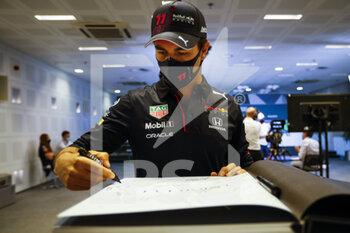 2021-12-09 - PEREZ Sergio (mex), Red Bull Racing Honda RB16B, portrait signing helmet and book for TODT Jean (fra), FIA President during the Formula 1 Etihad Airways Abu Dhabi Grand Prix 2021, 22th round of the 2021 FIA Formula One World Championship from December 10 to 12, 2021 on the Yas Marina Circuit, in Yas Island, Abu Dhabi - FORMULA 1 ETIHAD AIRWAYS ABU DHABI GRAND PRIX 2021, 22TH ROUND OF THE 2021 FIA FORMULA ONE WORLD CHAMPIONSHIP - FORMULA 1 - MOTORS