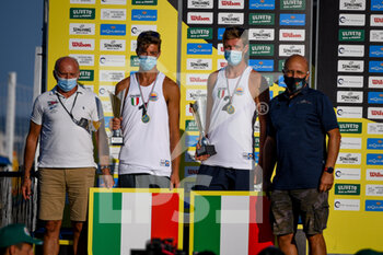 2021-09-05 - I campioni d'italia Samuele Cottafava e Jacob Windisch sul podio ricevono il trofeo per aver vinto il campionato italiano - CAMPIONATO ITALIANO ASSOLUTO 2021 - FINALE SCUDETTO MASCHILE - LOSIAK/BRYL VS CARAMBULA/ROSSI - BEACH VOLLEY - VOLLEYBALL