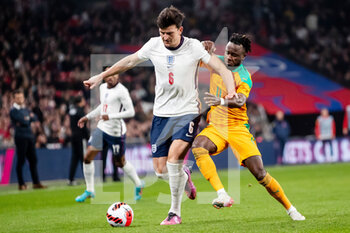 2022-03-29 - England defender Harry Maguire (6) battles for possession with Ivory Coast forward Maxwel Cornet during the Friendly football match between England and Ivory Coast on March 29, 2022 at Wembley Stadium in London, England - ENGLAND VS IVORY COAST - FRIENDLY MATCH - SOCCER