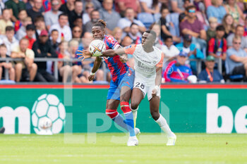 2022-07-30 - Crystal Palace forward Wilfried Zaha and Beni Makouana of Montpellier during the Pre-Season Friendly football match between Crystal Palace and Montpellier HSC on July 30, 2022 at Selhurst Park in London, England - FOOTBALL - FRIENDLY GAME - CRYSTAL PALACE V MONTPELLIER - FRIENDLY MATCH - SOCCER