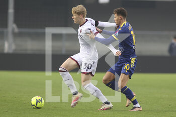 2022-12-22 - Ajdin Hrustic of Hellas Verona FC competes for the ball with Jerdy Schouten of Bologna FC during Hellas Verona vs Bologna FC, frendly match Serie A Tim 2022-23, at Marcantonio Bentegodi stadium in Verona (VR), Italy, on December 22, 2022. - HELLAS VERONA FC VS BOLOGNA FC - FRIENDLY MATCH - SOCCER