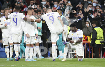 2022-03-09 - Karim Benzema of Real Madrid has his boots shined by Vinicius Junior after his third goal during the UEFA Champions League, Round of 16, 2nd leg football match between Real Madrid and Paris Saint-Germain (PSG) on March 9, 2022 at Santiago Bernabeu stadium in Madrid, Spain - REAL MADRID VS PARIS SAINT-GERMAIN - UEFA CHAMPIONS LEAGUE - SOCCER