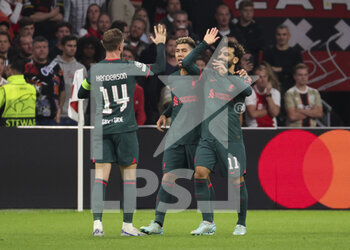 2022-10-26 - Mohamed Salah of Liverpool (right) celebrates his goal with Jordan Henderson, Roberto Firmino of Liverpool during the UEFA Champions League, Group A football match between Ajax Amsterdam and Liverpool FC on October 26, 2022 at Johan Cruijff ArenA in Amsterdam, Netherlands - FOOTBALL - CHAMPIONS LEAGUE - AJAX V LIVERPOOL - UEFA CHAMPIONS LEAGUE - SOCCER