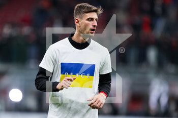 2022-03-01 - Matteo Gabbia of AC Milan warms up wearing a Ukrainian flag on their shirt to indicate peace and sympathy with Ukraine during the Coppa Italia 2021/22 football match between AC Milan and FC Internazionale at Giuseppe Meazza Stadium, Milan, Italy on March 01, 2022 - AC MILAN VS FC INTERNAZIONALE - ITALIAN CUP - SOCCER
