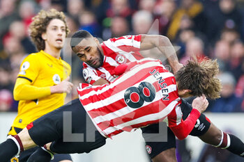 2022-01-22 - Rico Henry (3) of Brentford and Mathias Jensen (8) of Brentford clash during the English championship Premier League football match between Brentford and Wolverhampton Wanderers on January 22, 2022 at Brentford Community Stadium in Brentford, England - BRENTFORD VS WOLVERHAMPTON WANDERERS - ENGLISH PREMIER LEAGUE - SOCCER